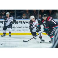 The Kelowna Rockets and Vancouver Giants chase after a loose puck